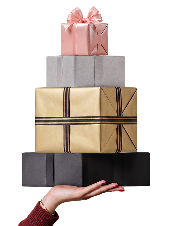 A hand holding a stack of wrapped holiday gifts